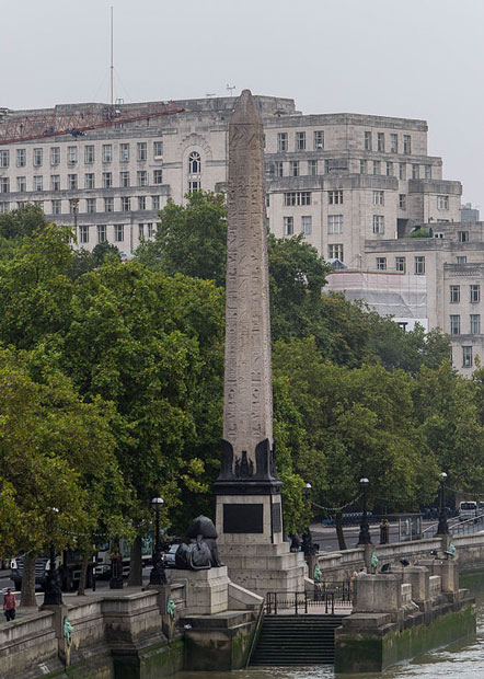 Cleopatra's Needle stands in London beside the Thames, flanked by two sphinxes 